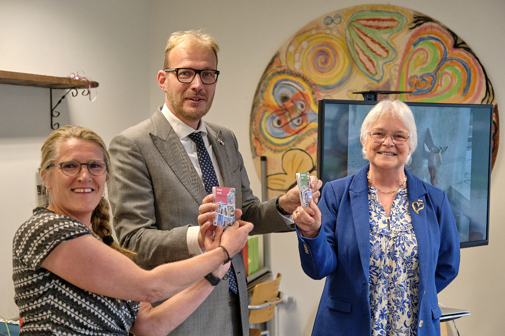 Burgemeester Mark Boumans neemt eerste exemplaren wandelroutes in ontvangst l. Saskia Bruil, r. Wilma Lankhorst © foto Jeroen Peters
